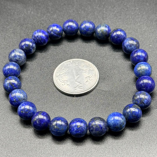 Lapis Lazuli AAA Bracelet with round blue beads arranged in a circle around a coin