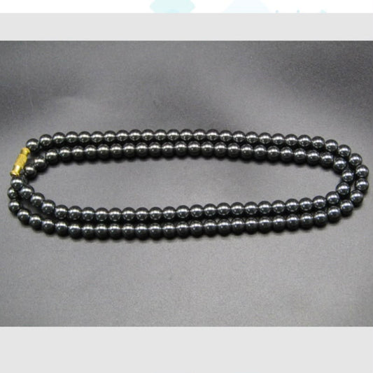 Hematite 6mm mala necklace with smooth round dark grey beads and a gold clasp on grey background