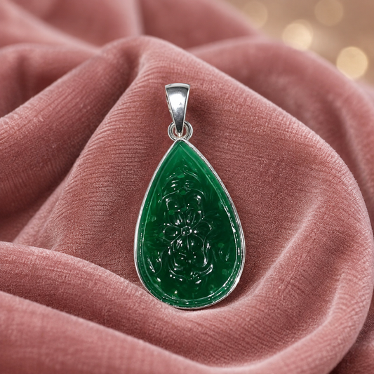 925 silver carved green onyx teardrop pendant with a bail, shown on pink fabric background