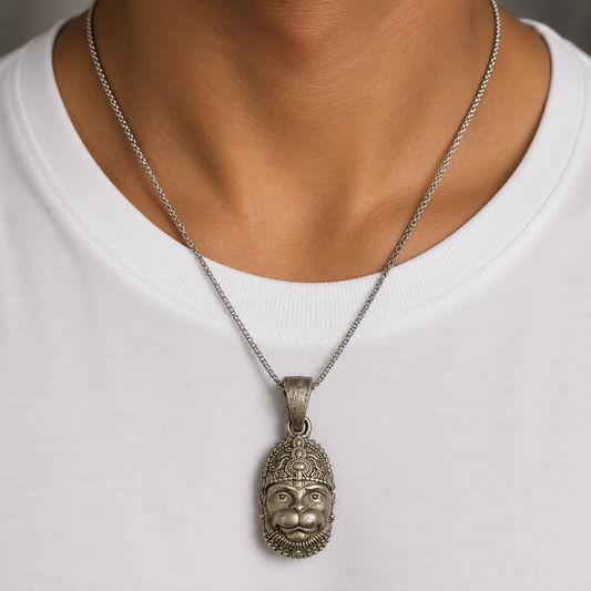Lord Hanuman face pendant in 925 silver hanging from a fine chain on a white shirt