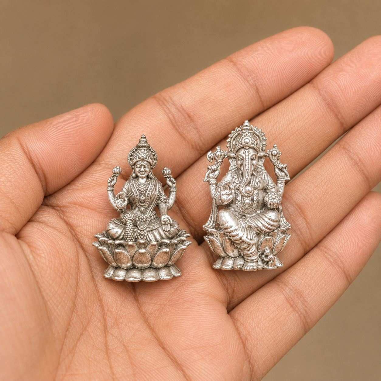 925 silver Lakshmi and Ganesha murti set shown on open palm for scale