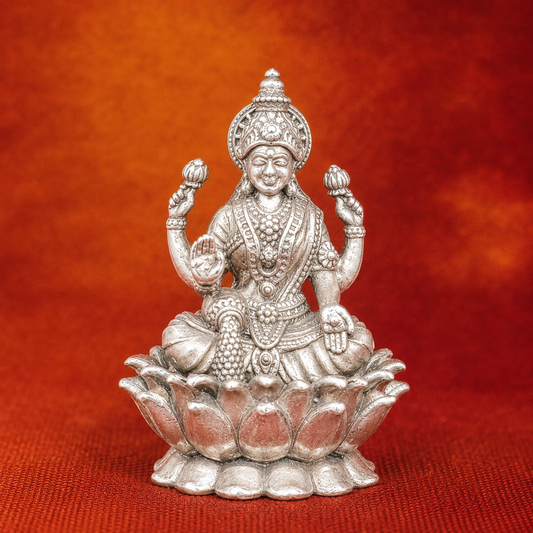 925 silver Lakshmi goddess murti seated on lotus with four arms on red fabric background