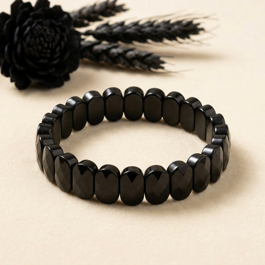 Natural Onyx Bracelet with oval faceted black beads arranged in a circle on beige background