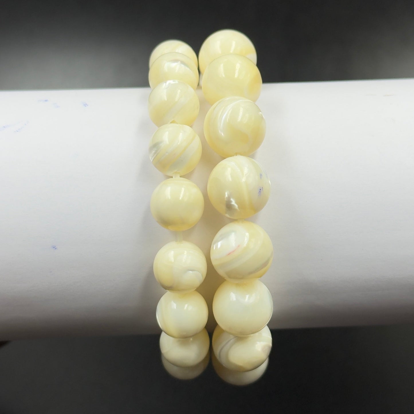 Mother of Pearl Bracelet showing polished round beads with subtle creamy and white swirls