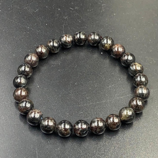 Astrophyllite bracelet close-up showing round dark beads with natural speckled pattern