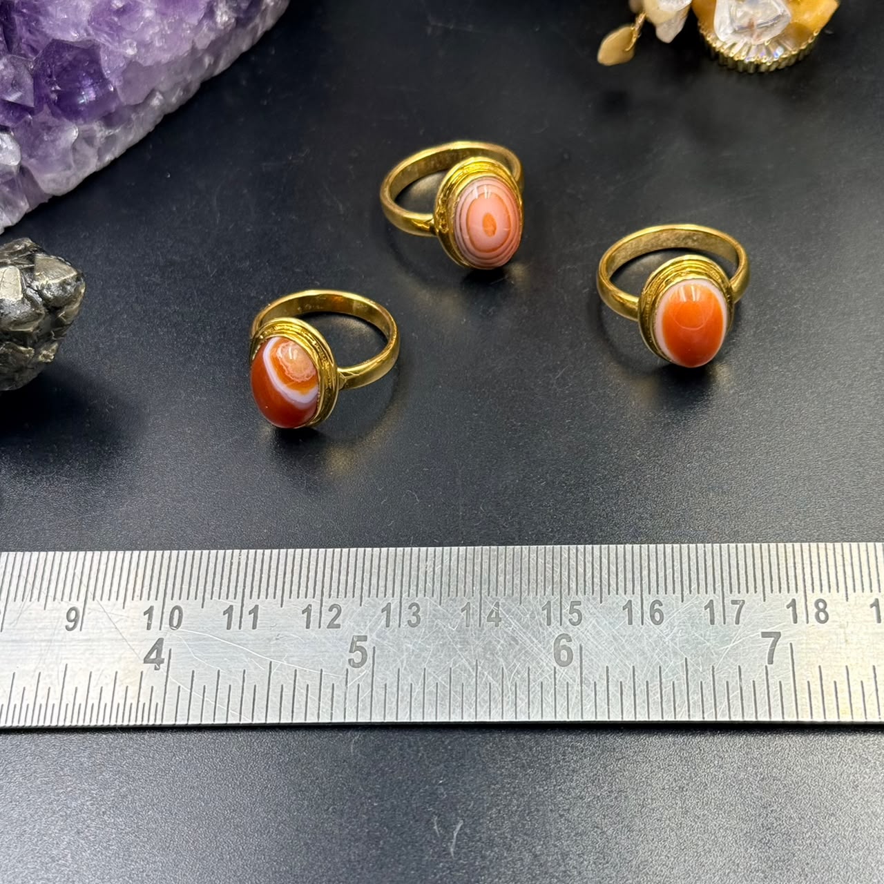 Carnelian Panchdhatu ring set in gold tone with orange cabochon stones, measured on ruler