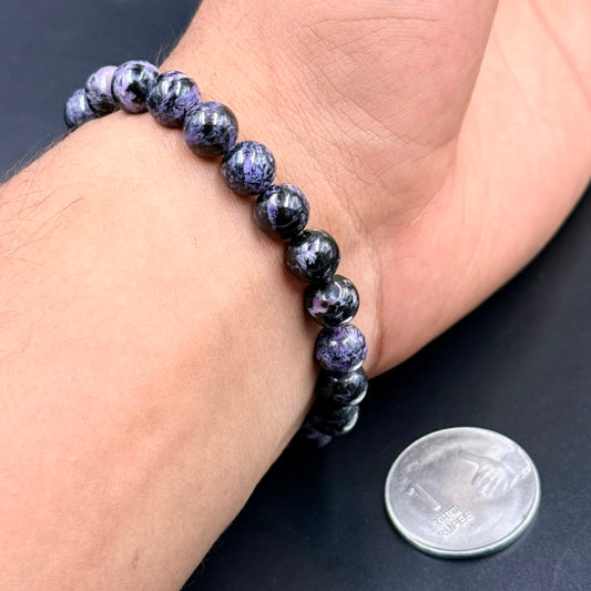 Charoite AAA beaded bracelet worn on wrist with coin for scale