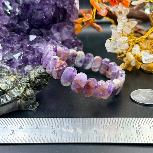 Chevron amethyst flat oval bead bracelet close-up with purple and peach beads on dark surface