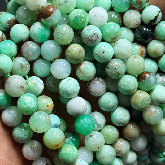 Close-up of green chrysoprase mala beads with natural stone speckles and variation