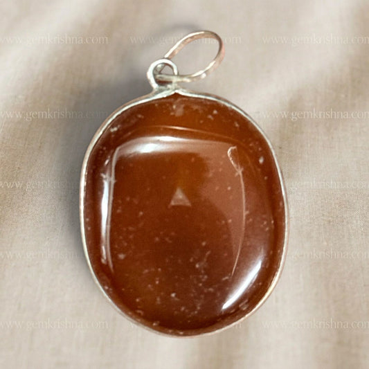 Close-up natural carnelian locket pendant with silver-toned bail and oval stone window