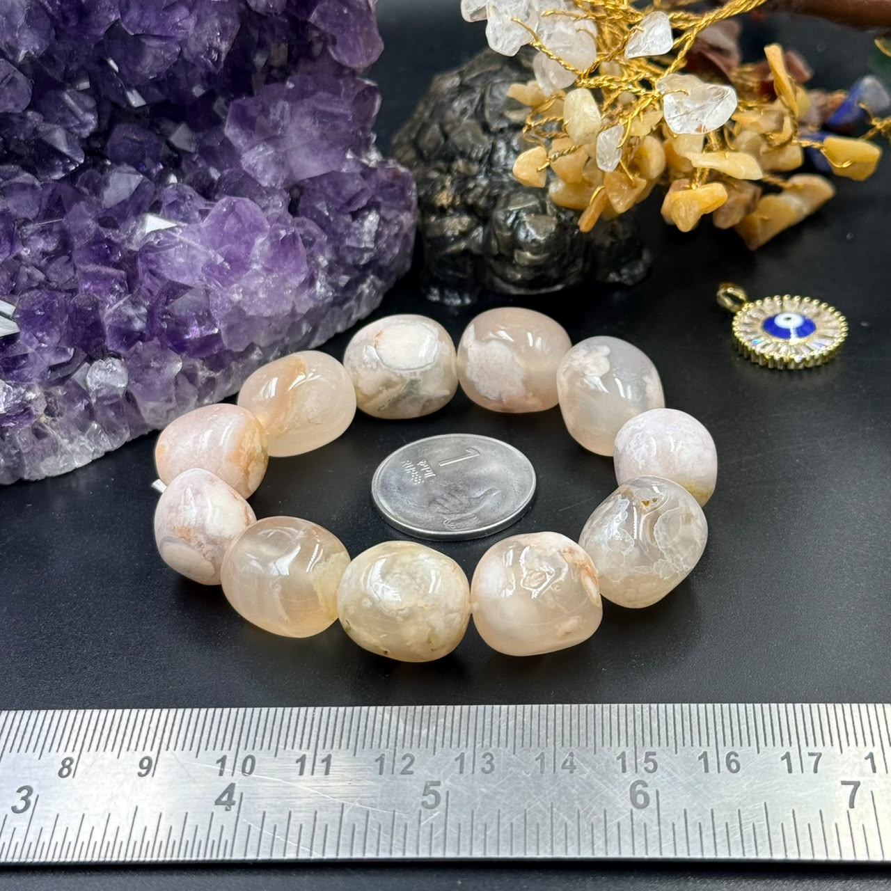 Flower agate tumble bracelet with peach and cream beads measured beside a ruler on black surface