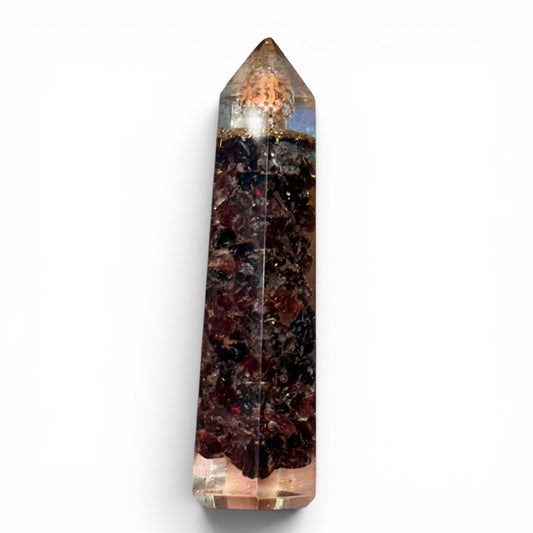 Garnet crystal tower with pointed top and faceted base on a white background