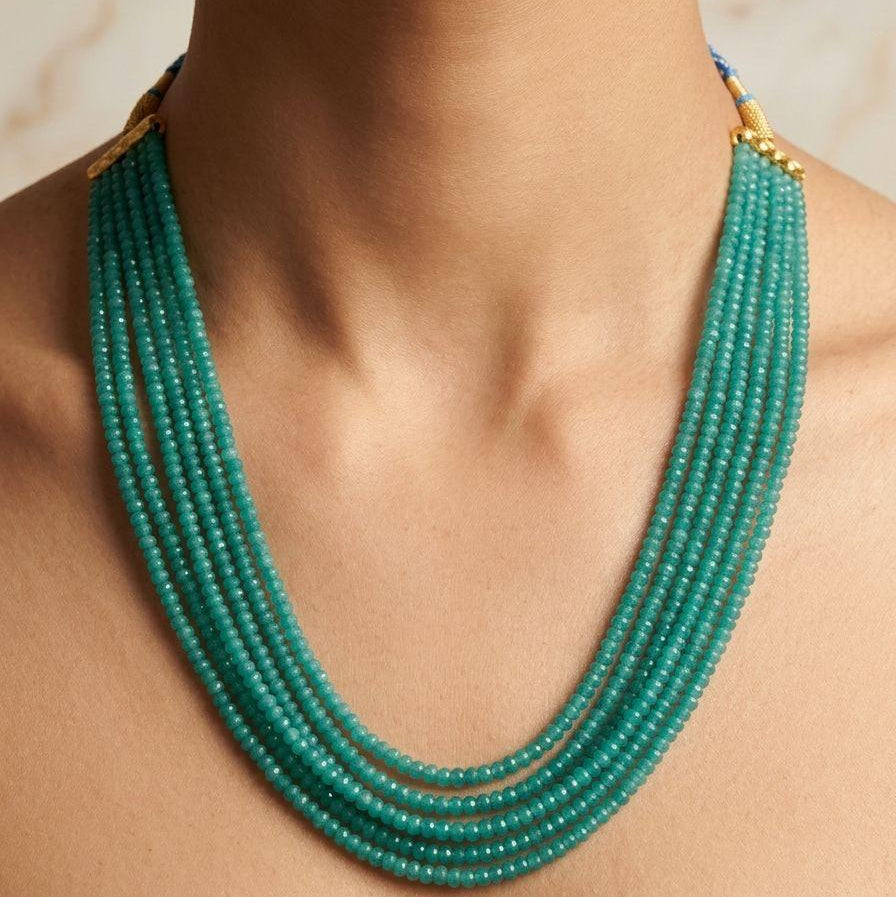 Close-up of green onyx mala necklace 6-line bead strand on a wearer’s neck