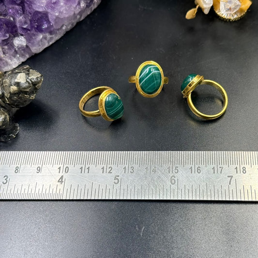 Green Sulemani Panchdhatu ring with oval green gemstone on gold-toned band, side angle view