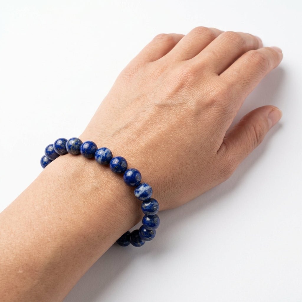 Natural lapis lazuli bracelet worn on hand with round blue gemstone beads