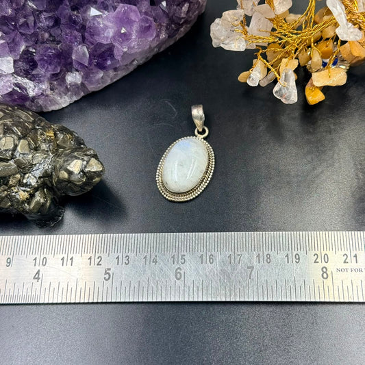 Moonstone oval locket pendant front view in 925 silver bezel setting on dark background
