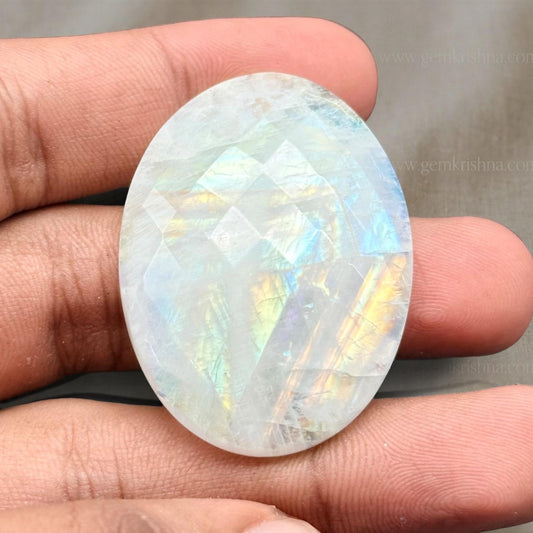 Moonstone faceted palm stone showing pearly rainbow reflections held in hand