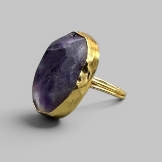 Natural amethyst rough metal ring with gold-toned band angled view on gray background