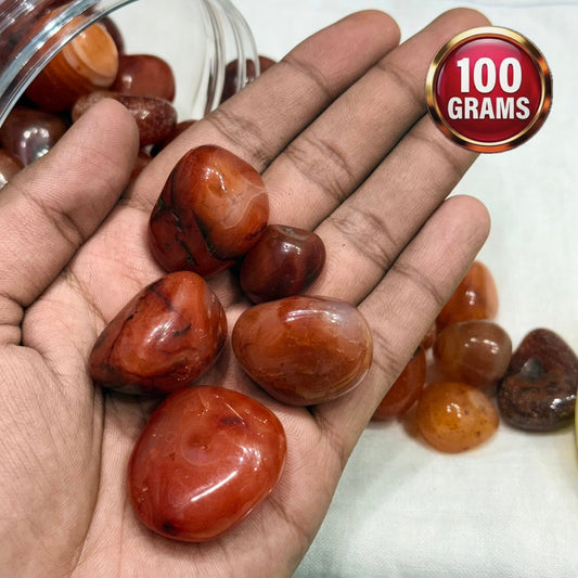 Natural carnelian tumble stones in hand with 100 grams weight label badge
