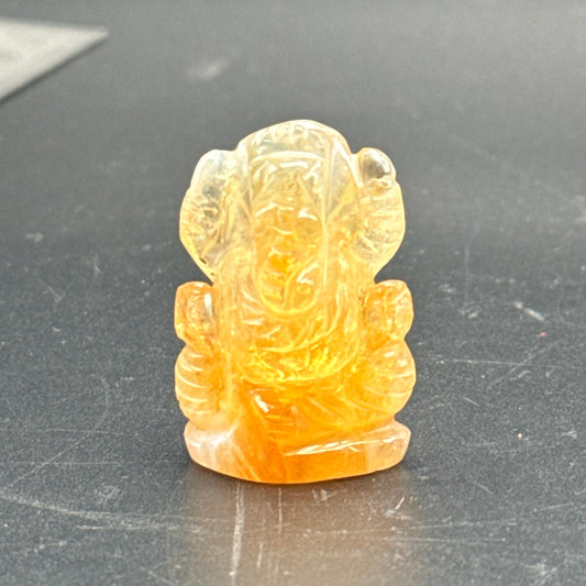 Natural citrine Ganesh Ji carving standing figurine, front view on dark background