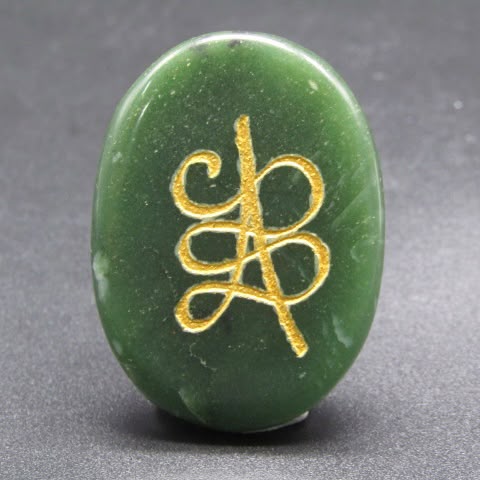 Natural green jade coin pendant with gold harmony symbol front view on gray background