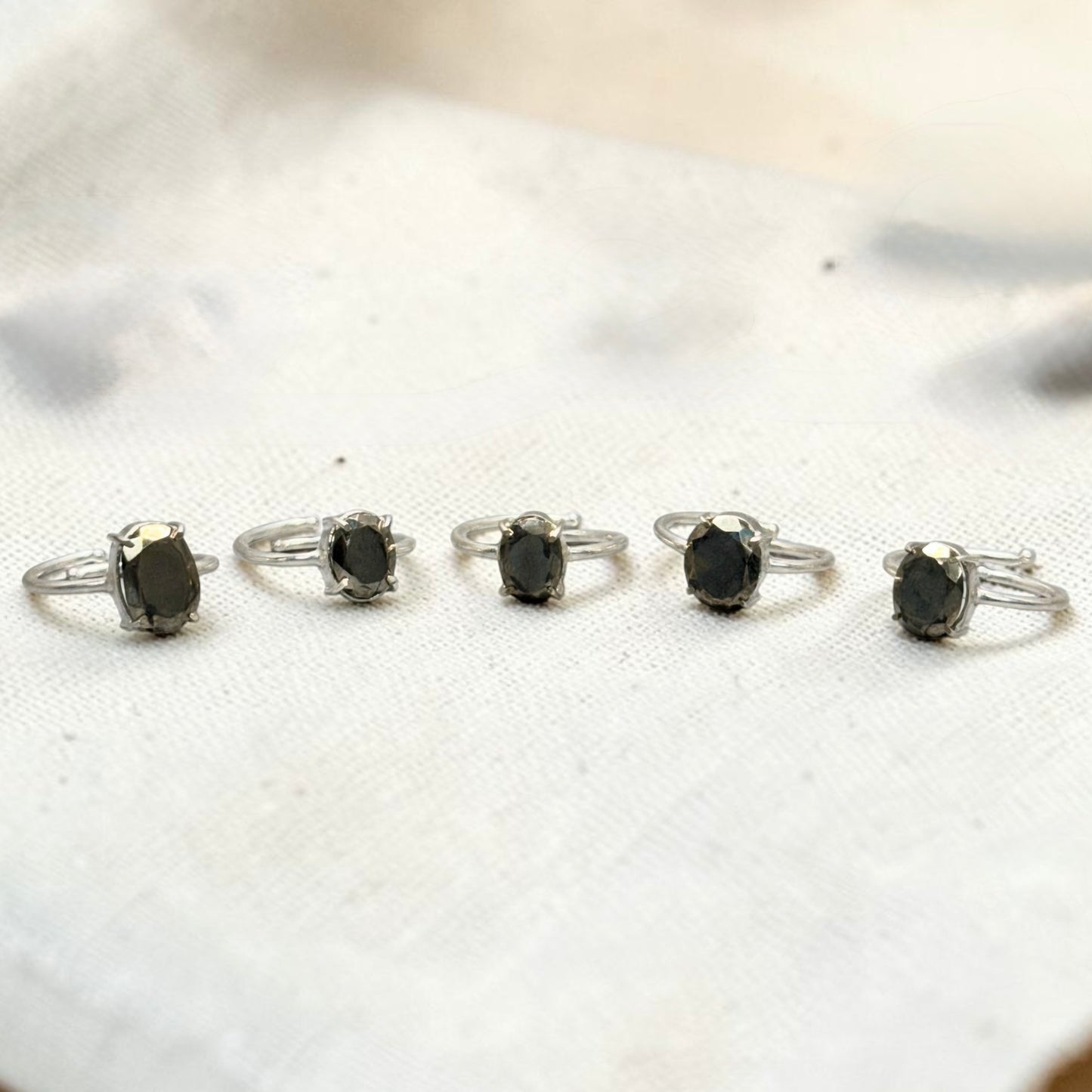 Natural pyrite adjustable ring set of four views on white background, oval dark stone in silver