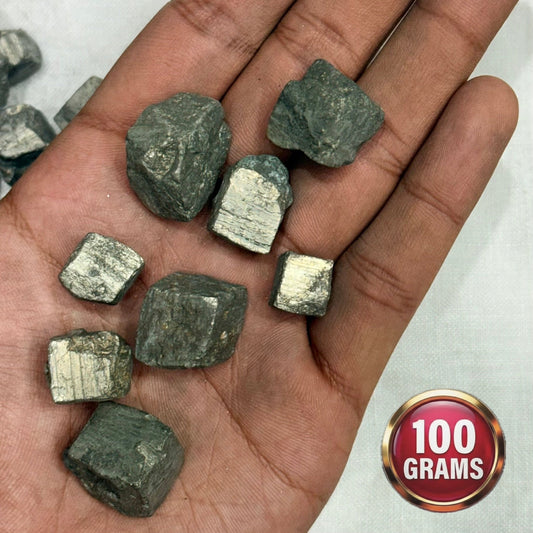 Natural pyrite cubes in hand, rough metallic dark grey square pieces