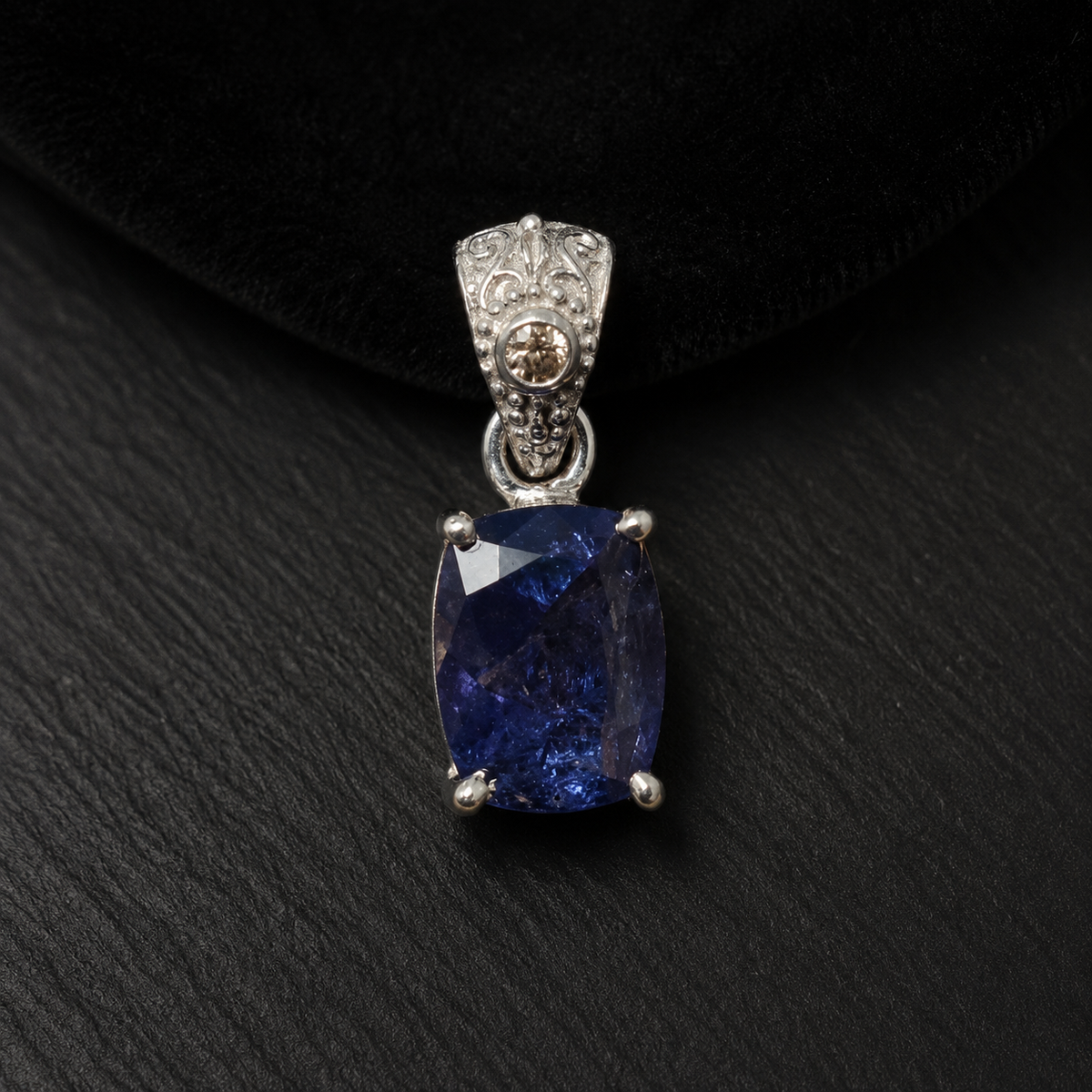 Natural tanzanite and lab-grown diamond pendant in 925 silver, front view on black velvet