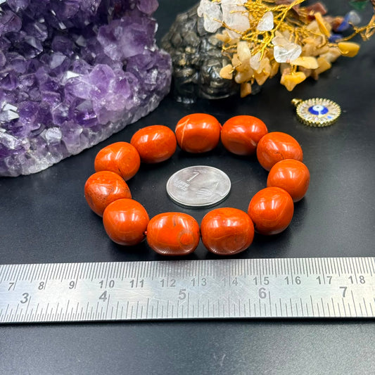 Red jasper tumbler bracelet with round orange-red beads shown beside a size ruler