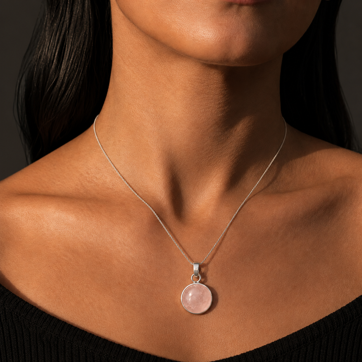 Woman wearing natural rose quartz cabochon pendant necklace set in German silver