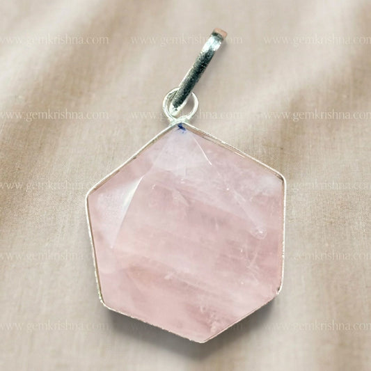 Rose quartz hexagon locket pendant close-up with hanging bail on light fabric