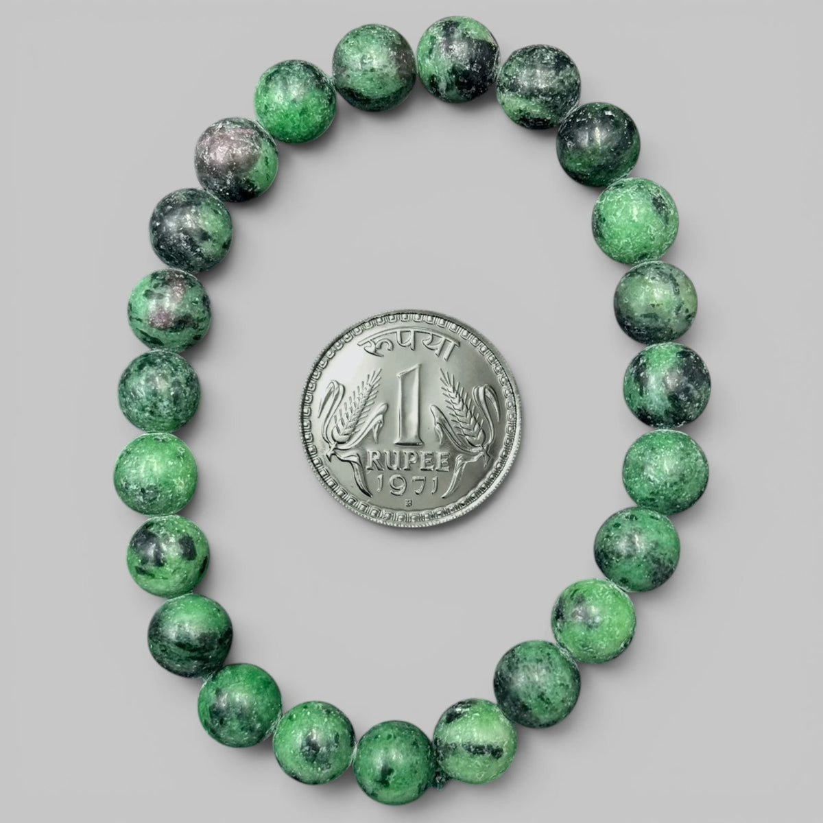 Ruby zoisite bracelet with mixed green round beads and a rupee coin for size