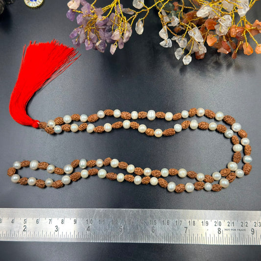 Rudraksha and 6mm pearl japa mala strands with red tassel on dark surface