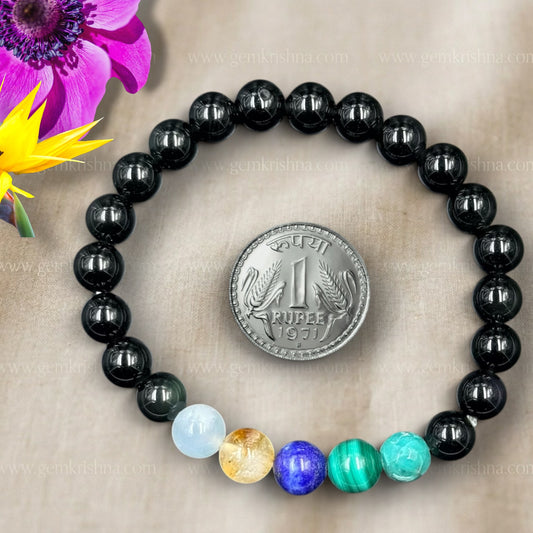 Scorpio bracelet featuring black round beads and colorful gemstone beads with coin for scale close-up