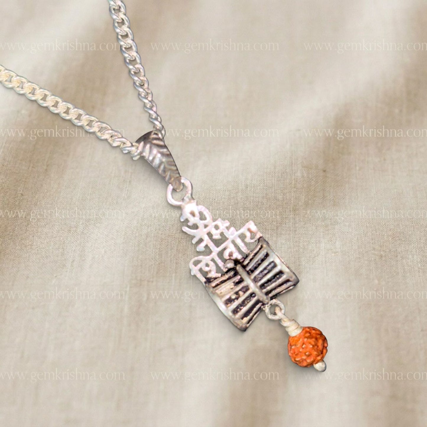 925 silver Shivling and Trishul pendant with rudraksha bead on a chain on beige background