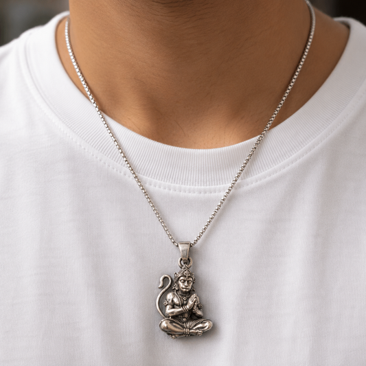 Lord Hanuman namaste pendant hanging on a silver chain worn on a model neck