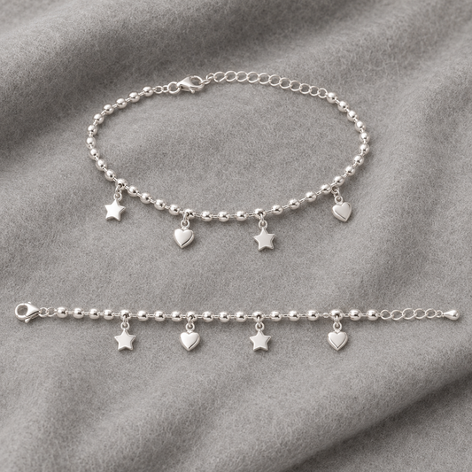 Sterling silver star and heart charm beaded anklet laid flat on gray fabric