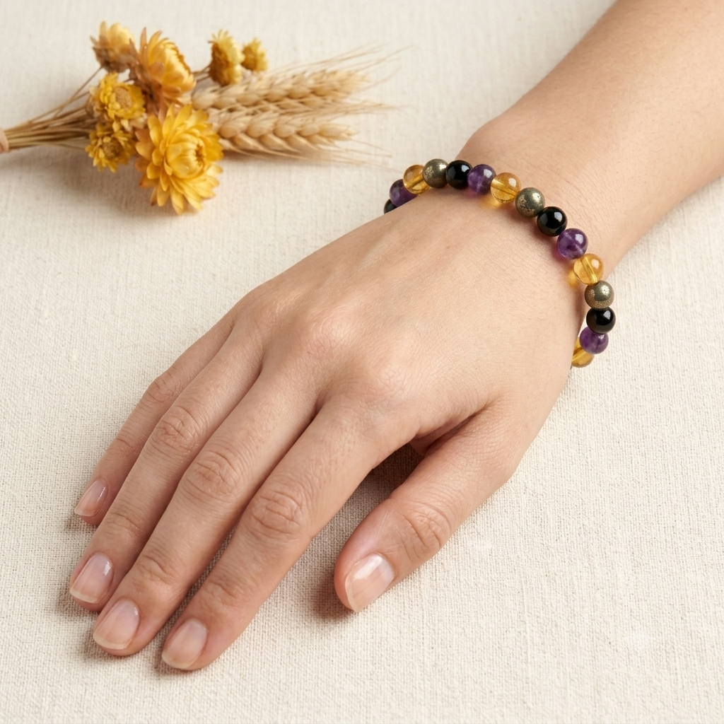 Success & Protection Bracelet on wrist with purple amethyst and black beads and gold-toned citrine accents