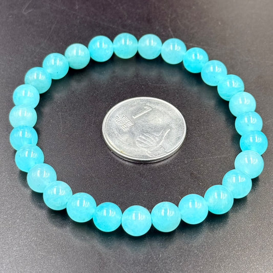 Round teal amazonite beaded bracelet with coin for size comparison on dark surface