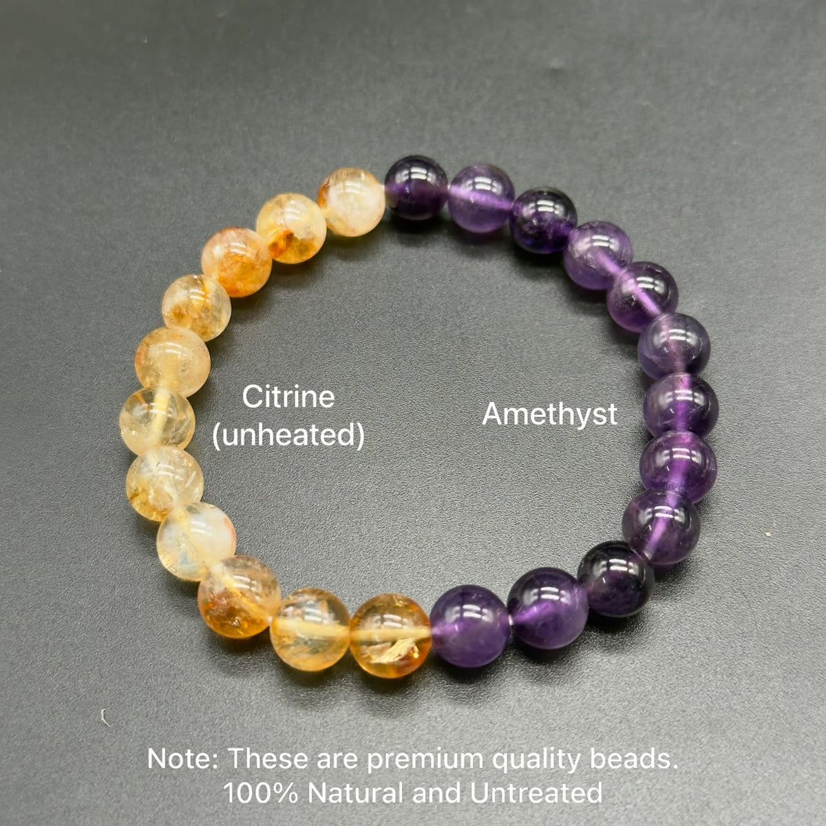 Unheated citrine and untreated amethyst round bead bracelet on dark textured background