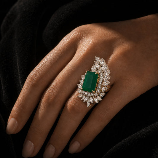 18K gold emerald-cut emerald and diamond halo ring on hand, side view
