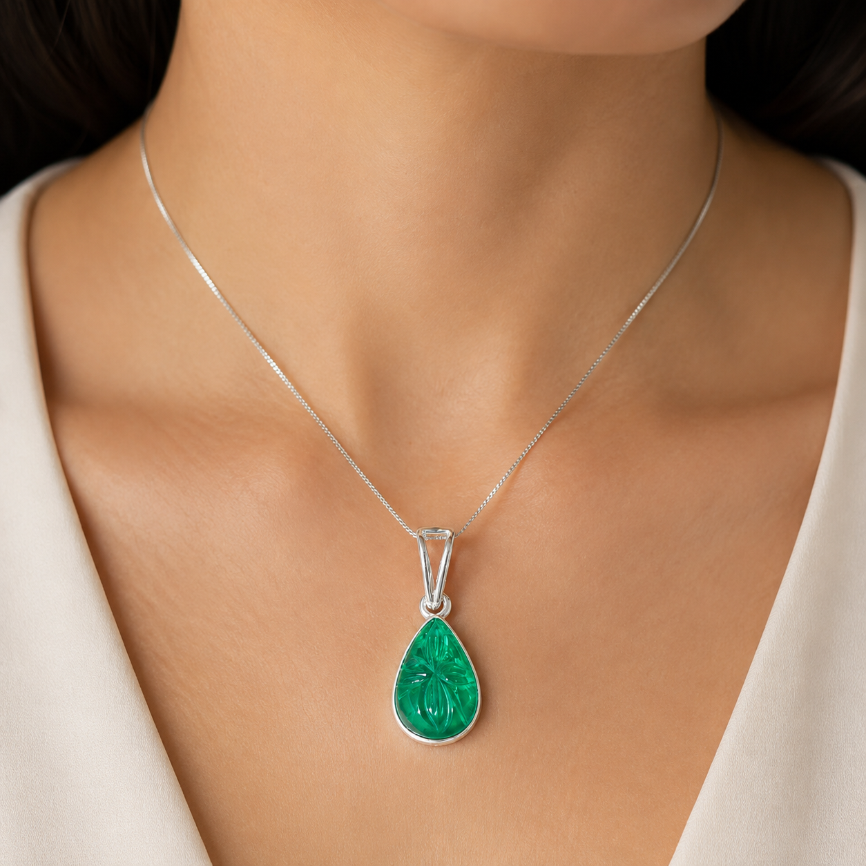 Carved green onyx teardrop pendant in 925 silver worn on a delicate chain