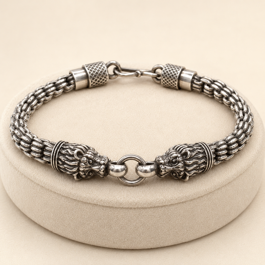 925 silver men’s double lion-head bracelet with textured barrel accents and clasp, laid on jewelry stand