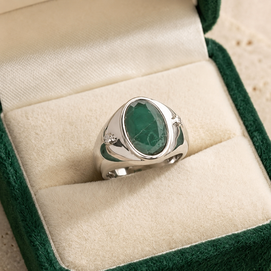 925 silver oval emerald panna ring with small side stones on a jewelry box