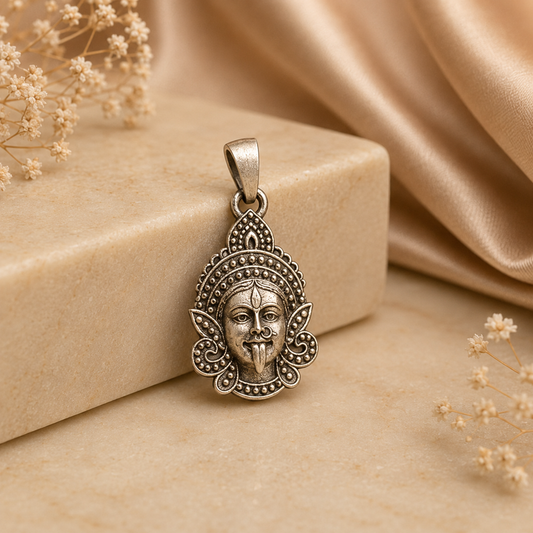 925 silver Maa Kali face pendant with ornate circular detailing, on a beige display block