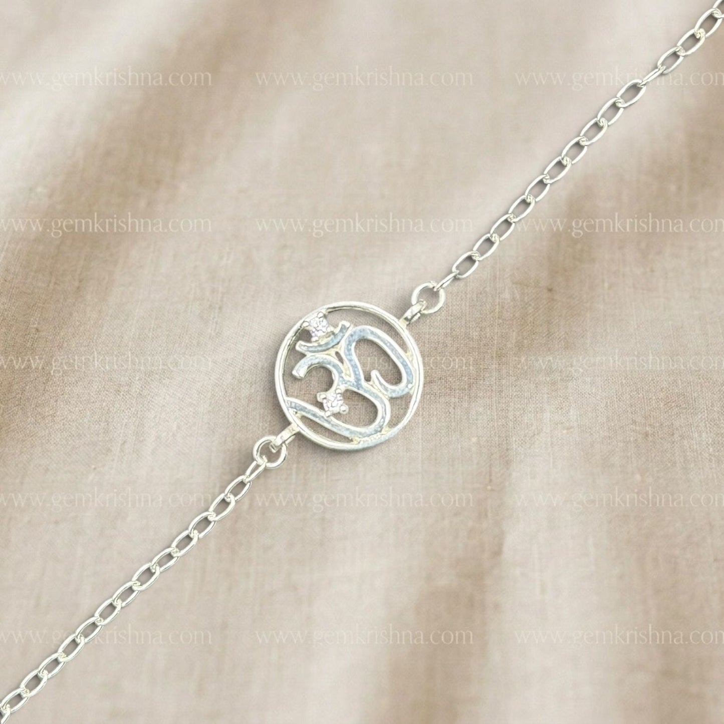 925 silver Om bracelet with blue enamel spiritual symbol and chain links on beige background