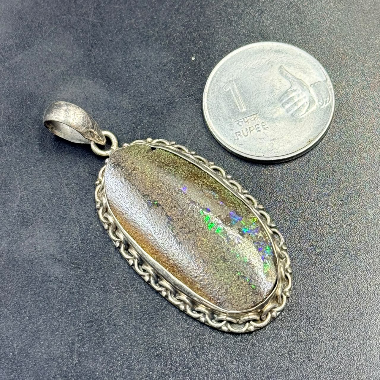 925 silver opal locket pendant with oval opal stone and hinged frame on dark background