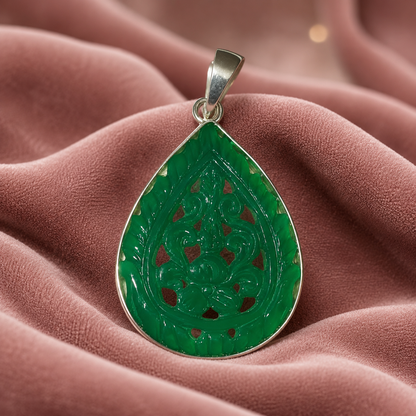 Close-up of 925 silver openwork green onyx teardrop pendant with engraved design