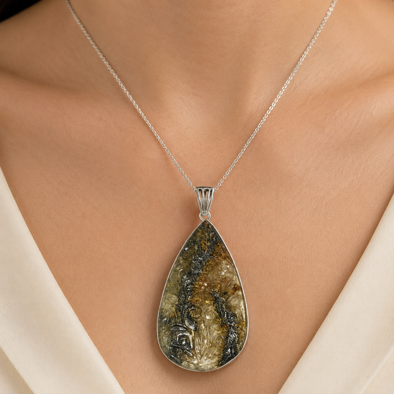 925 silver rutilated quartz pendant on a silver chain against light fabric background