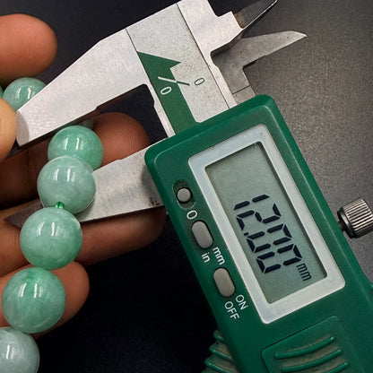 Jadeite Jade Apple Green Top Quality Premium AAA Bracelet beads being measured with digital caliper at 12 millimeters